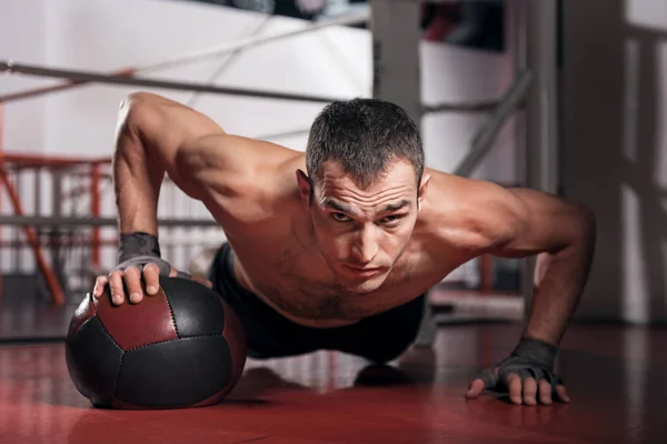 Uomo muscolare che fa flessioni con palla fitness — Foto Stock