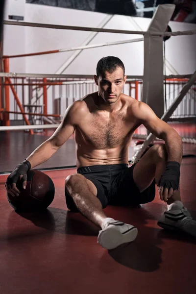 Deportista guapo sentado en el gimnasio del piso —  Fotos de Stock