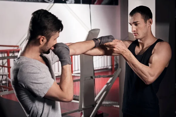 Entraîneur enseignant à un homme comment boxer — Photo