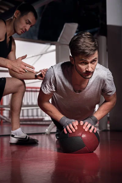 Uomo che fa flessioni con allenatore utilizzando palla fitness — Foto Stock