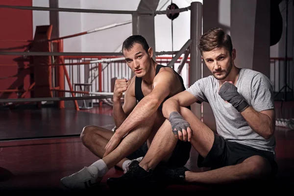 Two men sitting on floor in boxing position — Stock Photo, Image