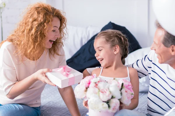 Happy little girl receiving a present from her grandparents — Stock Photo, Image