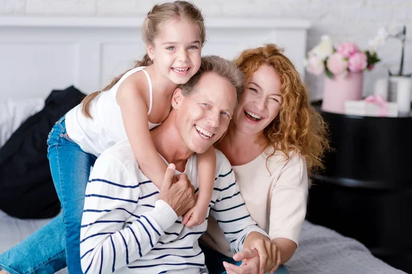 Vrolijk meisje lachen met haar grootouders — Stockfoto