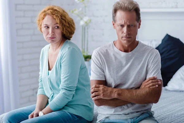 Depressief leeftijd man en vrouw zitten op het bed — Stockfoto