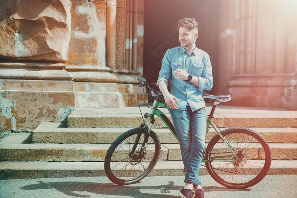 Lelaki yang tersenyum berdiri di dekat sepeda — Stok Foto