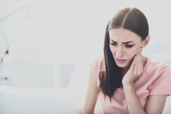 Beautiful sick woman suffering from toothache.