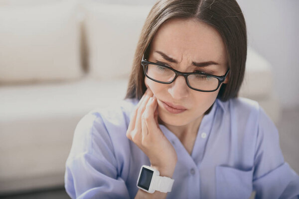 Exhausted young woman having toothache.