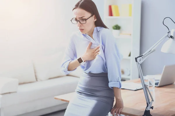 Mujer joven de buen aspecto nerviosa y apoyada en la mesa . — Foto de Stock