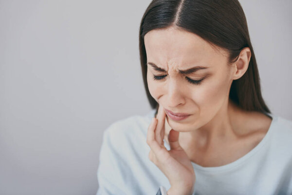 Close up of beautiful young woman which having toothache.
