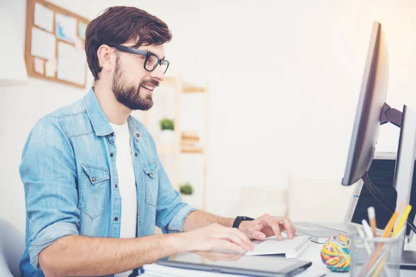 Hombre sonriente programando en una oficina — Foto de Stock