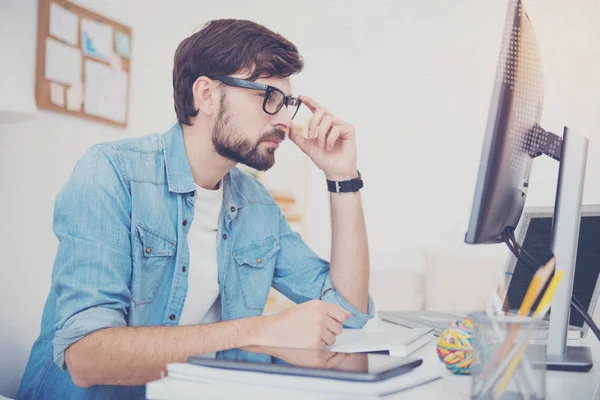 Junge Programmiererin blickt auf Computerbildschirm — Stockfoto