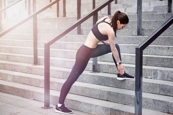 Chica activa en una ropa deportiva que se abalanza en las escaleras — Foto de Stock
