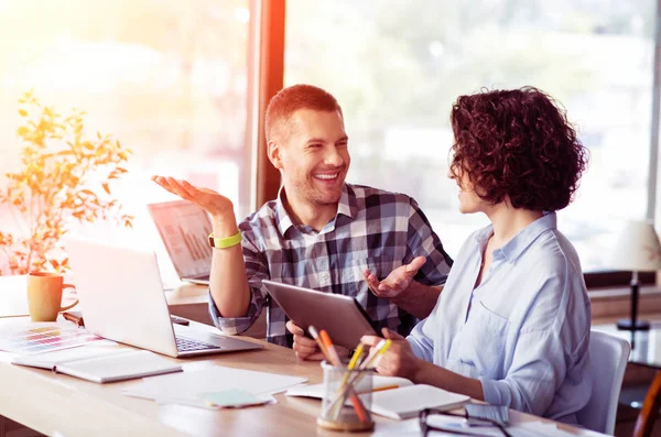 Colegas sonrientes y positivas hablando en la mesa — Foto de Stock