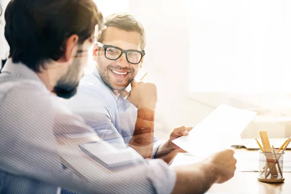 Hombre sonriente durante la reunión de negocios con su pareja — Foto de Stock