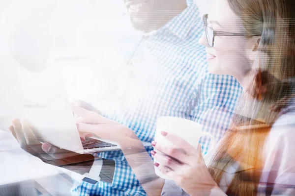 Young pretty woman pointing on laptop of her colleague — Stock Photo, Image