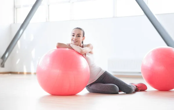 Bir fitness topu yaslanmış güzel memnun kadın — Stok fotoğraf