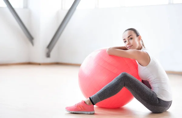 Dobry patrząc trwałe kobieta siedzi w pobliżu piłka fitness — Zdjęcie stockowe