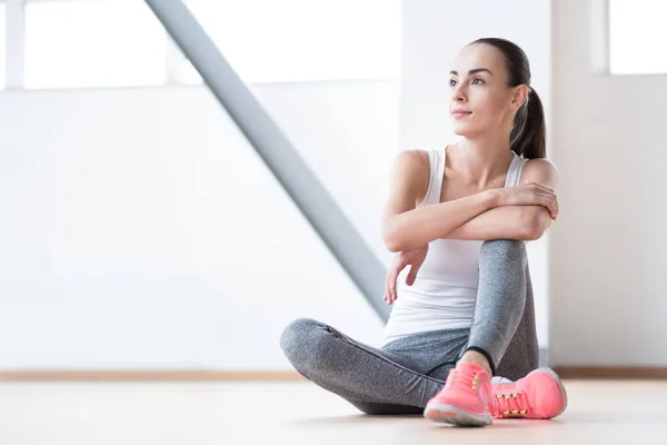 Allvarlig bra söker kvinna sitter på golvet — Stockfoto