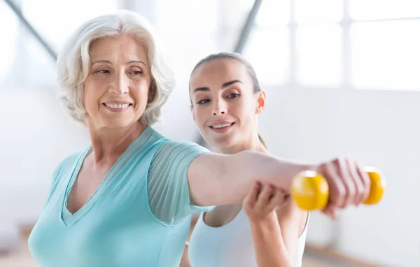 Mujer optimista alegre haciendo ejercicio con un entrenador —  Fotos de Stock