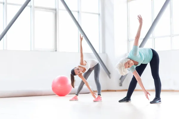 Mulheres alegres ativas que se exercitam em um clube de fitness — Fotografia de Stock