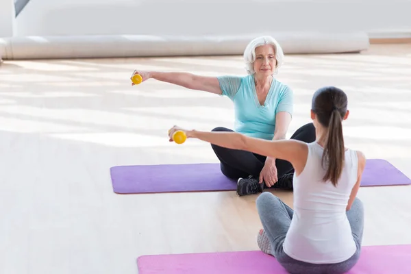 Спокійна літня жінка тренується на килимку для йоги — стокове фото