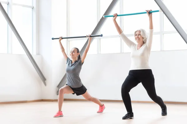 Mujeres bonitas positivas sosteniendo palos de plástico — Foto de Stock