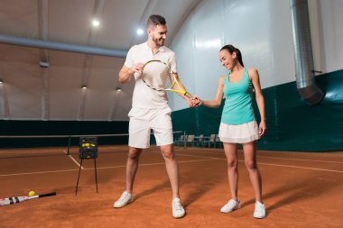 Profesyonel eğitmen genç kadın tenis oynamak için öğretim