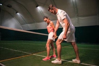 Tenis oynamak için genç kadın öğretim profesyonel instructror