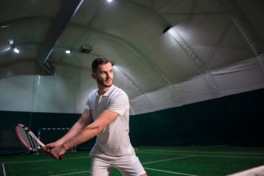 Profesyonel oyuncu kapalı mahkemede tenis oynamaya