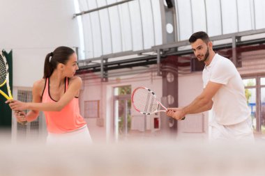 Profesyonel eğitmen genç kadın tenis oynamak için öğretim