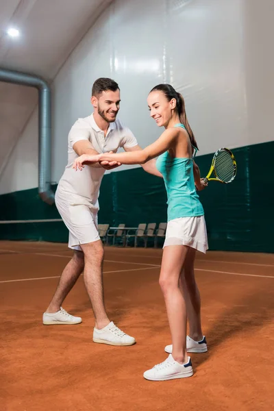 Instrutor profissional ensinando jovem magro mulher para jogar tênis — Fotografia de Stock
