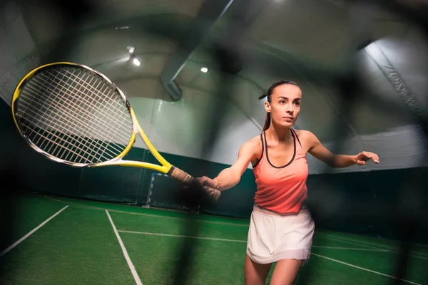 Ernsthafte junge Frau spielt Tennis — Stockfoto