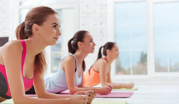 Three concentrated women doing a plank in gym — Stock Photo, Image