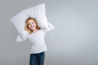 Sevimli kız holding yastık gülümseyen