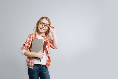 Kitap tutan genç gülümseyen öğrenci