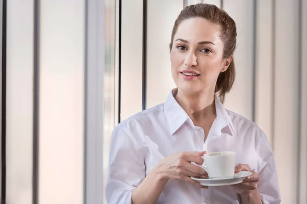 Donna gioiosa godendo di pausa caffè in ufficio accogliente — Foto Stock
