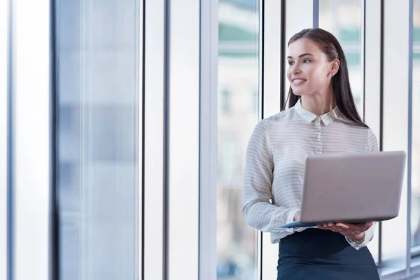 Mulher morena usando laptop em um escritório — Fotografia de Stock