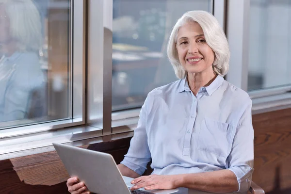 Mujer mayor que trabaja en un ordenador portátil en una oficina — Foto de Stock