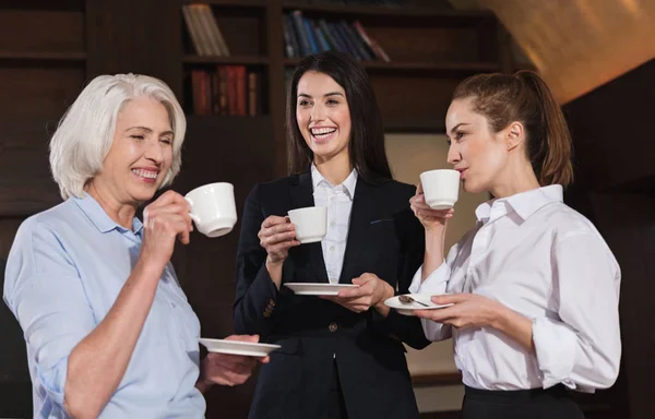 Colegas divertidos bebendo café em um escritório — Fotografia de Stock