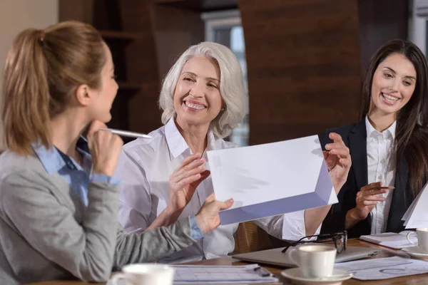 Tres colegas disfrutando de la conversación sobre el trabajo — Foto de Stock