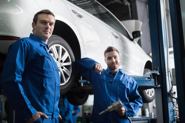 Mecánico de coche guapo va a cambiarla rueda — Foto de Stock