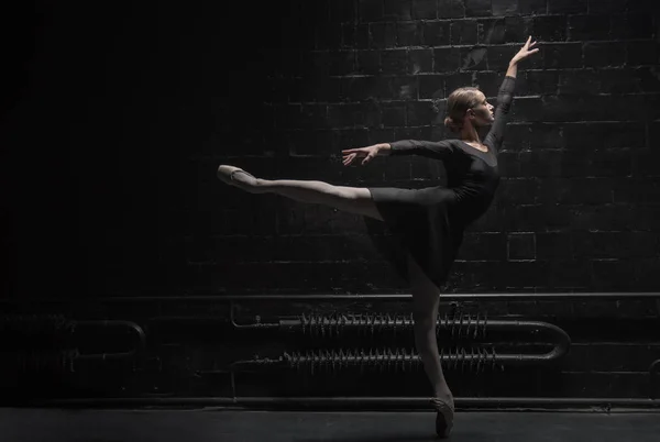 Concentrated young dancer training near the dark wall — Stock Photo, Image