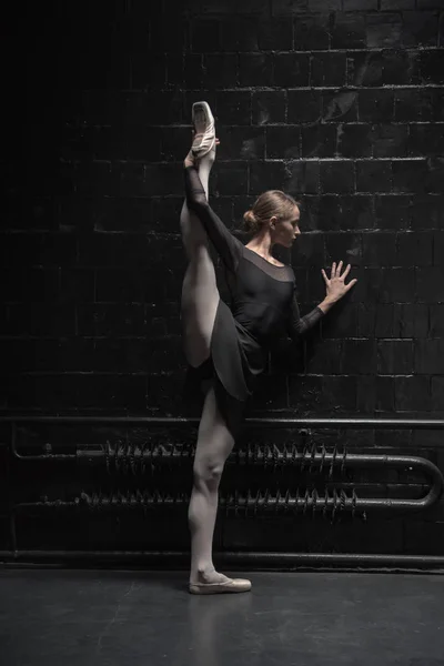 Junge Tänzerin beim Training nahe der schwarzen Wand — Stockfoto