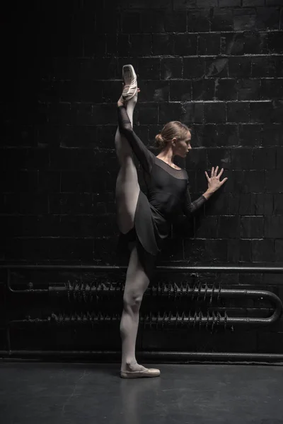 Jonge danseres opleiding in de buurt van de zwarte muur — Stockfoto