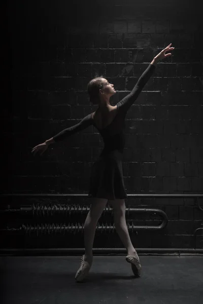 Изящная танцовщица позирует в темной комнате — стоковое фото