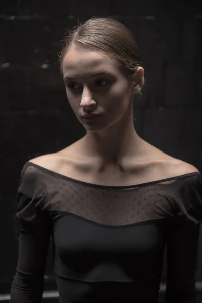 Концентрированная танцовщица, стоящая в темной комнате — стоковое фото