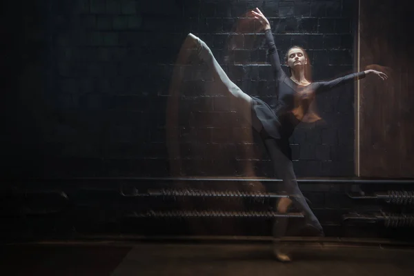 Young dancer jumping in front of the black wall — Stock Photo, Image