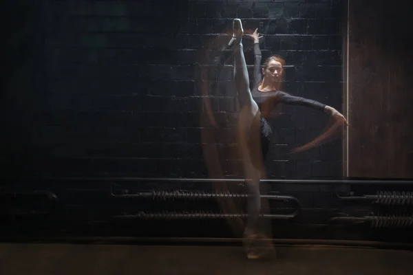 Young gymnast showing her twine on the dark background — Stock Photo, Image