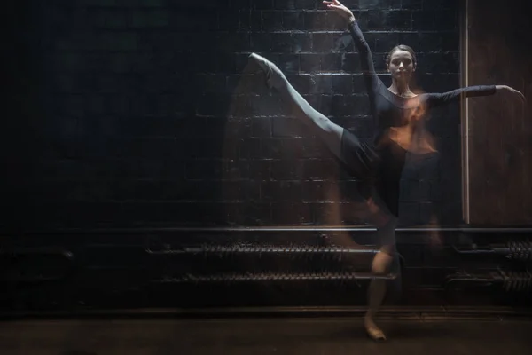 Jovem ginasta em movimento no quarto iluminado escuro — Fotografia de Stock