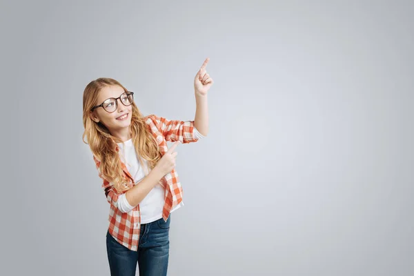 Menina alegre apontando para o lado — Fotografia de Stock